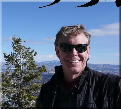 Photo of Jerry Michelsen with Bryce Canyon in the background. Jerry's smiling and wearing sunglasses on a bright, blue day.